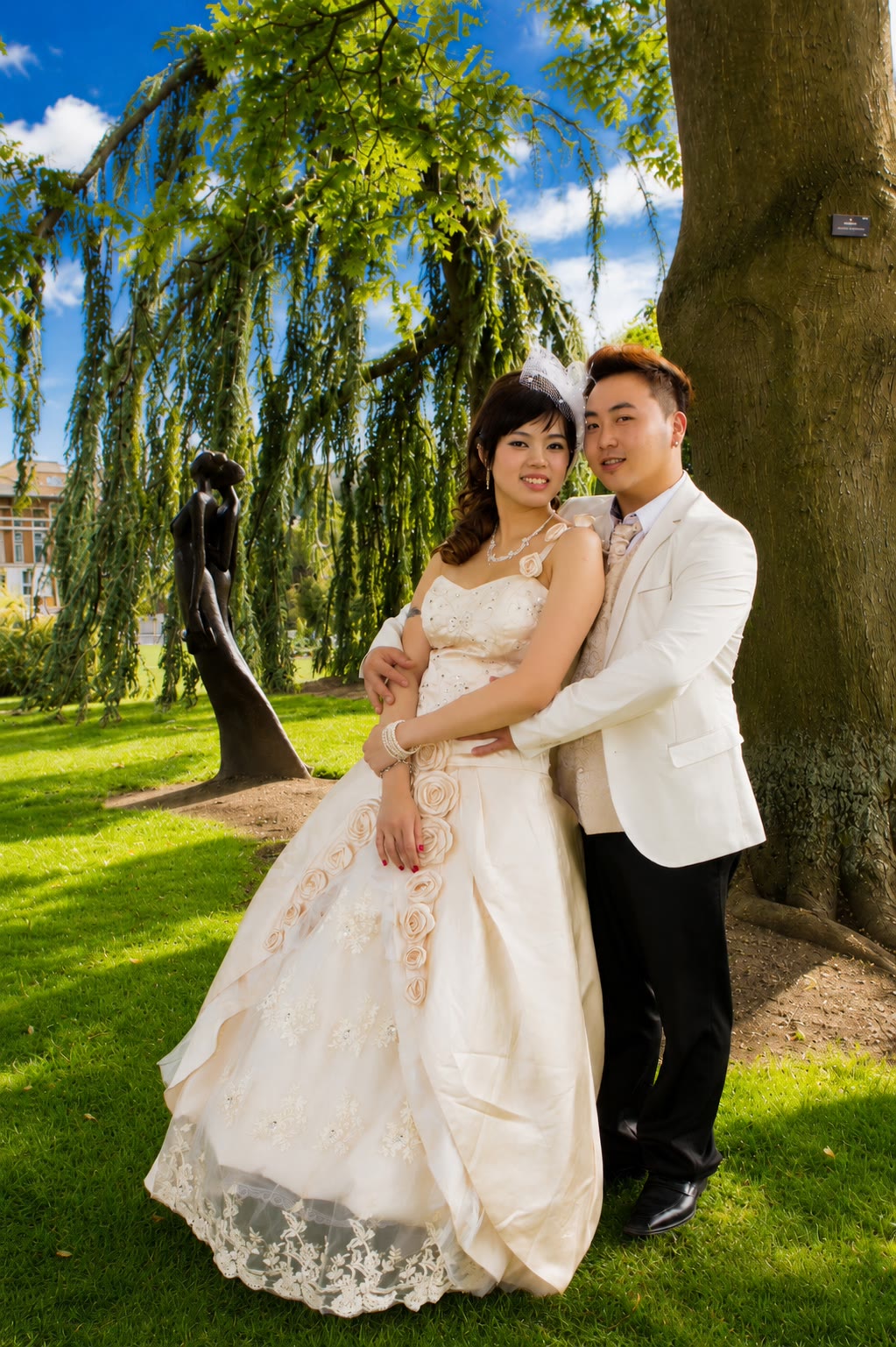 Kenzo and May posing beneath a garden tree